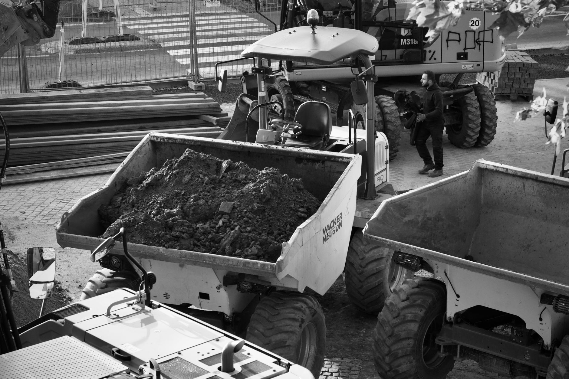 construction site with heavy machinery and worker in black and white